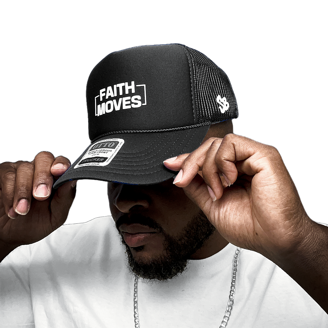 Black Faith Moves trucker hat with white embroidered logo, worn by model adjusting the brim – mesh back and SB logo visible

